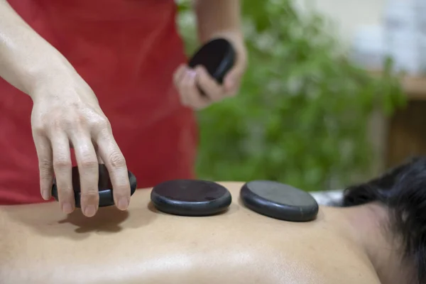 Spa Hot Stone Massage, putting on back — Stock Photo, Image