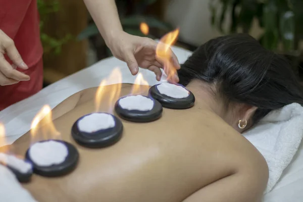 Girl having basalt stones therapy and skincare in spa salon. Luxary interior in therapy. Female bare back with smooth skin have relax . — Stock Photo, Image