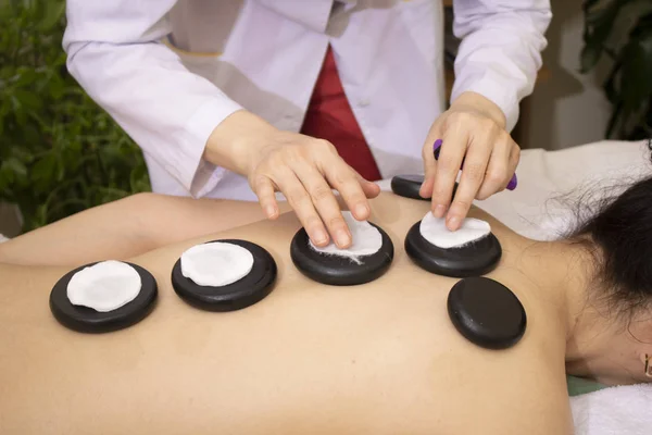 Steintherapie. Massage mit warmen Basaltsteinen. Fokus auf die Hände — Stockfoto