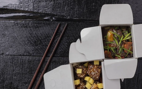 Delicioso envase wok fideos caja con udon y pollo en la mesa de madera. chino y asiático takeaway rápido comida plana laico —  Fotos de Stock