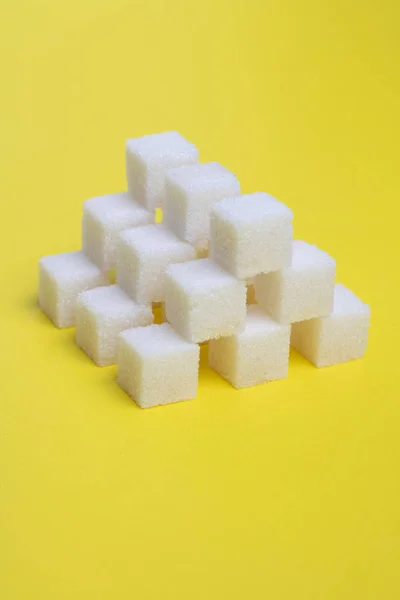 Cubes blancs de shugar sur fond jaune, photo de nourriture verticale — Photo
