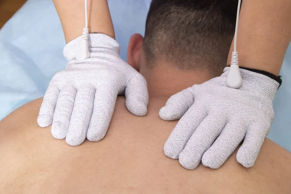 Homem tendo massagem nas costas, fisioterapia com luvas — Fotografia de Stock