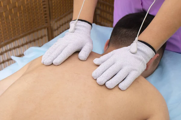 Mężczyzna mający masaż pleców, fizjoterapia z rękawiczkami — Zdjęcie stockowe