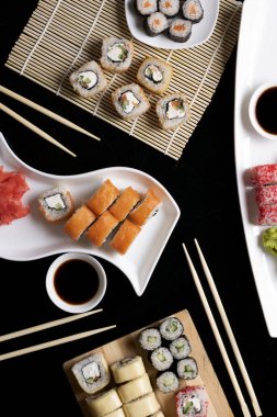 Çubuklu suşi. Suşi restoranda Japon yemeği yapar. Kaliforniya suşisi, somon ve sebzeli. Dikey resim