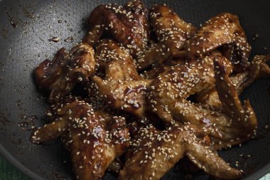 Tavuk kanatlı tava Tayland yemeği tarifi için karamelize ediliyor.