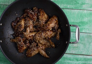 Tavuğu tavada pişir, yeşil ahşap masada, dümdüz uzan.