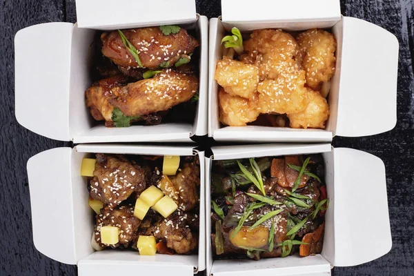 Comida wok, carne y fideos en cuatro cajas de papel, vista superior, libre de plástico —  Fotos de Stock