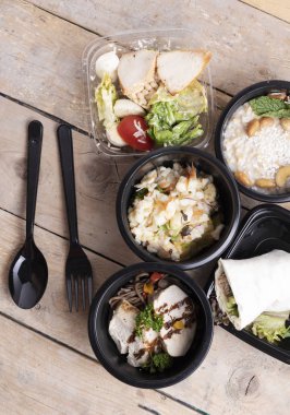 Lezzetli yemek plastik kaplarda ahşap masa yakın çekim