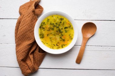 Çorba ve et suyu beyaz tabakta, ahşap kaşık, üst görüş ve metin için yer