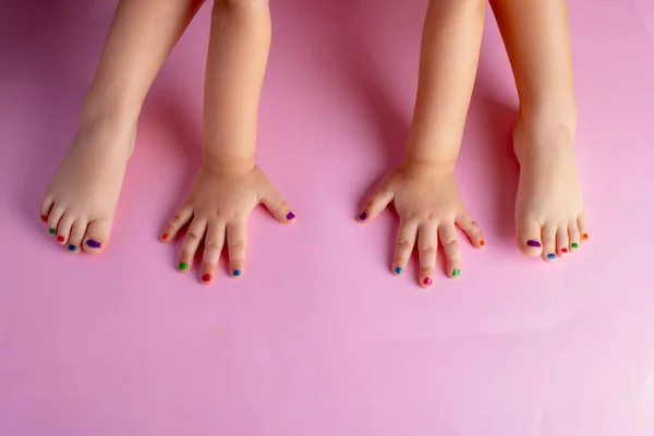 painted nails on bare feet and hands, manicure and pedicure concept