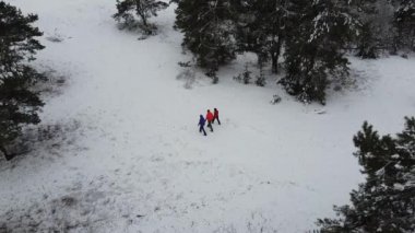 A group of tourists is on the trail. A drone flying above people