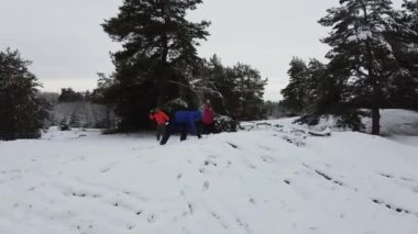 Three persons play snowballs. Fly around.