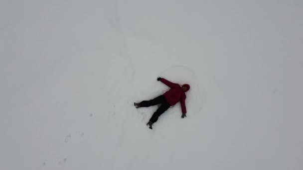 Aerial View Woman Lying Snow Hands Draws Wings Angel Winter — 图库视频影像