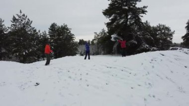 Three persons play snowballs. Side view 