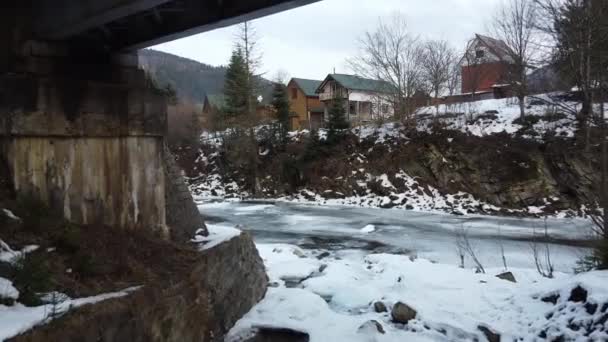 Halvfrusen Flod Täckt Isströmmar Mellan Hus Och Järnväg — Stockvideo