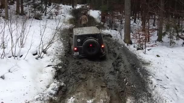 帮人把绞车的缆绳从山上雪地的泥泞中拖了出来 — 图库视频影像
