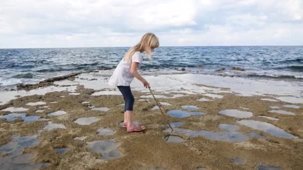 一个金发碧眼的女孩正在地中海沿岸寻找宝藏 — 图库视频影像
