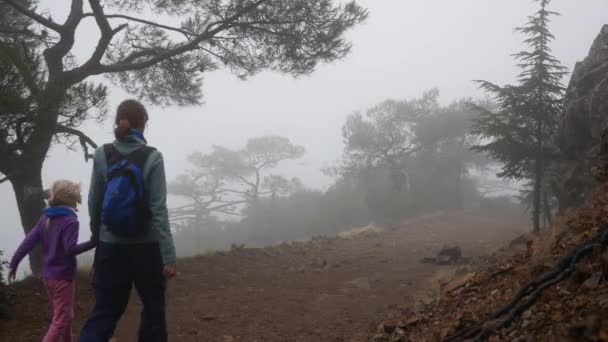 母と娘は山の中でオリンパス山に向かっています 濃い霧 — ストック動画