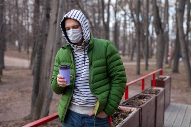 Bir fincan kahve ve tıbbi maskeli bir adam. Coronavirus 'un eğlenceli portresi.