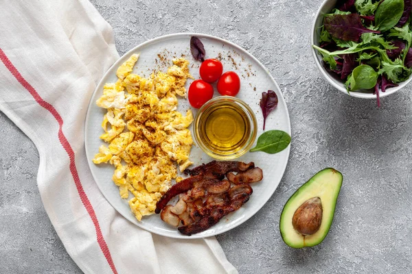 Domuz pastırması, domates, avokado ve zeytinyağlı omlet. Sağlıklı yağ kavramı.