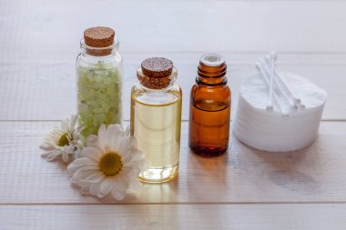 Tahta beyaz arka planda papatya çayı içerikli doğal kozmetik ürünler.