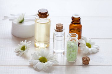 Papatya çayı içerikli cilt bakım ürünleri: yağ, serum, beyaz ahşap üzerine yüz kremi, üst görünüm