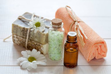 Hafif ahşap arka planda papatya özlü saf cilt bakımı kozmetiği.