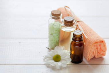 Organik kozmetik ürünler: yağ, tuz, beyaz ahşap zemin üzerinde bitkisel bileşenler içeren serum, düz zemin