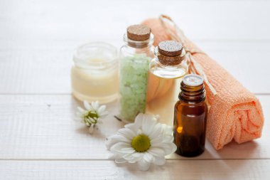 Beyaz ahşap arka planda bitkisel içerikli doğal kozmetik ürünleri, yakın plan.