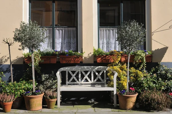 Small white bench on a house wall — Stock Photo, Image