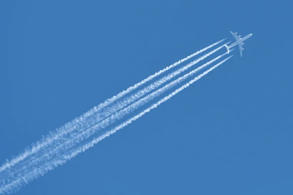 Avião com trilhas de avião — Fotografia de Stock