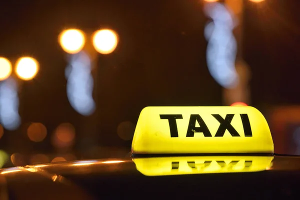 Een gele taxi bord op de avond — Stockfoto