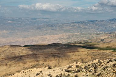 Ürdün 'deki İncilsel Nebo Dağı' ndan günbatımı ışıklarıyla manzara. Musa 'nın vaat edilmiş toprakları Ürdün çöl vadisinde gördüğü Nebo Dağı' nın tepesinden manzarayı seyret.
