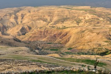 Ürdün 'deki İncilsel Nebo Dağı' ndan günbatımı ışıklarıyla manzara. Musa 'nın vaat edilmiş toprakları Ürdün çöl vadisinde gördüğü Nebo Dağı' nın tepesinden manzarayı seyret.