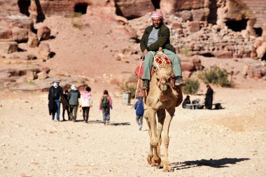 Petra, Ürdün - 18 Şubat 2020. Arap Bedevi Rehberi Ürdün 'ün Petra şehrinde at sürüyor. Petra, ülkenin UNESCO Dünya Mirası listesine girmesini sağladı..
