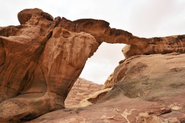 Wadi Rum Çölü 'ndeki Fruth Rock Köprüsü. Wadi Rum, Ürdün 'ün güneyinde kum taşı ve granit kayalara kesilen bir vadidir.