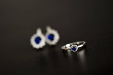 Yüzük ve doğal ışık masada mavi taş küpe