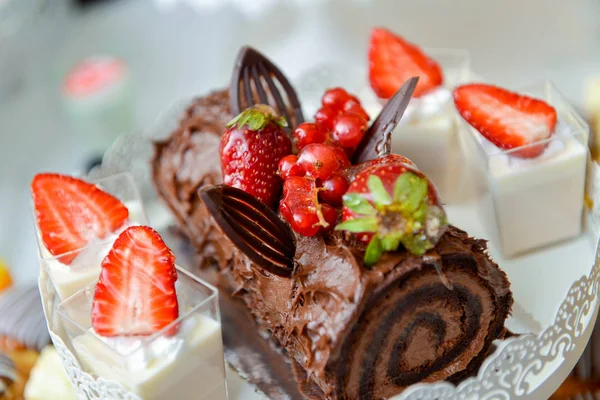 Schokoladenroulade mit Erdbeeren auf dem Tisch — Stockfoto