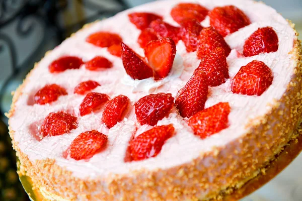 Torte mit Erdbeeren und Schlagsahne auf dem Tisch — Stockfoto