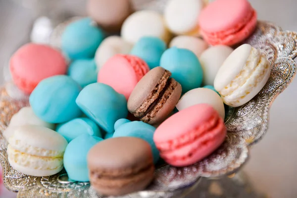 Színes macarons az asztalon egy tányéron — Stock Fotó