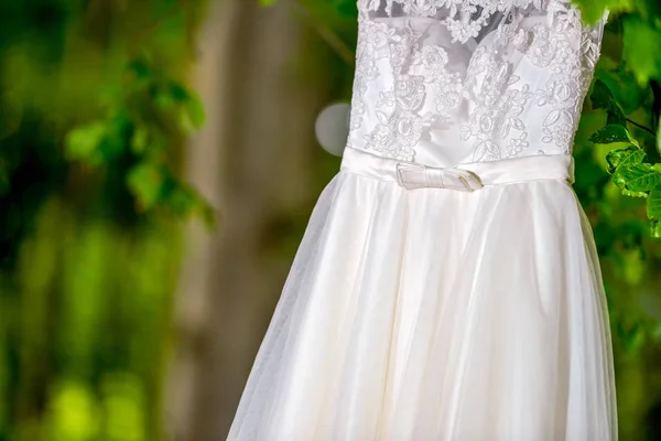 Vestido de novia colgado en luz natural — Foto de Stock