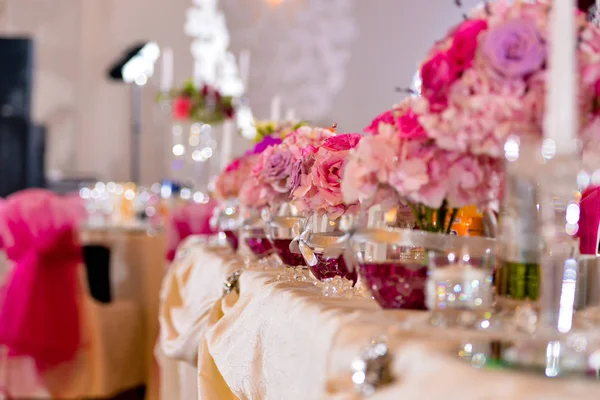 Arrangements mit rosa Blumen auf der hellen Seite des Tisches — Stockfoto