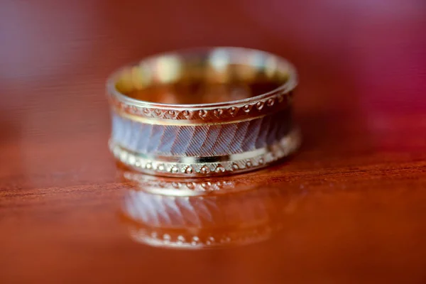 在光明的一面放在桌上的结婚戒指 — 图库照片