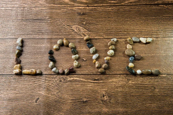 愛の石と書かれた木製の背景 — ストック写真