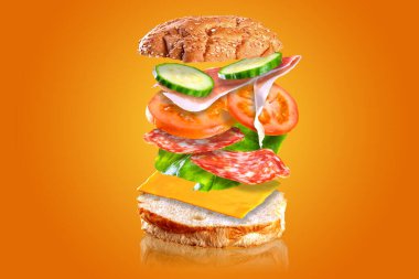 Uçan lezzetli sandviç. Turuncu arka planda izole edilmiş, uçan malzemeli sandviç..