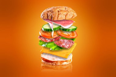 Uçan lezzetli sandviç. Turuncu arka planda izole edilmiş, uçan malzemeli sandviç..