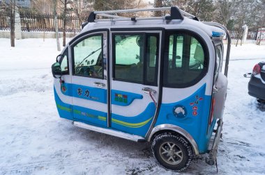 Üç tekerlekli motorlu scooter Hunchun Çin sokaklarında bir taksi ile