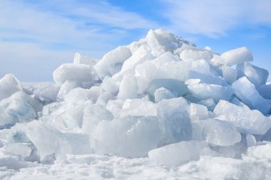 Mavi gökyüzüne karşı güneşte parlayan buz kalıpları.