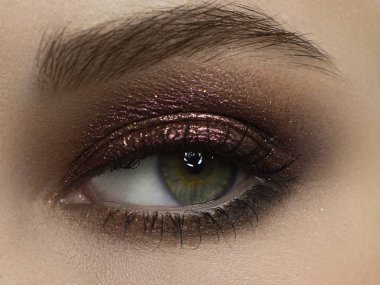 Koyu kahverengi göz farı olan zarif, yakın plan kadın gözü. Güzel bir kadının yüzünün makro görüntüsü. Sağlık, kozmetik ve makyaj. pürüzsüz güzel kaşlar ve kirpiklerle