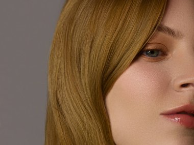 Yarı yüzü kızıl saçlı, çilli ve uzun saçlı. Temiz cilt, açık makyaj, seksi görünüş. Dudaklarda ruj izi, gözlerde kalem, yanaklarda hafif kızarıklık. Spa ve kozmetoloji